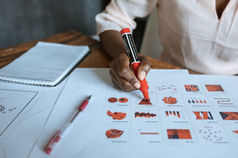 Researcher arranging printed figures on a desk to plan a manuscript storyline